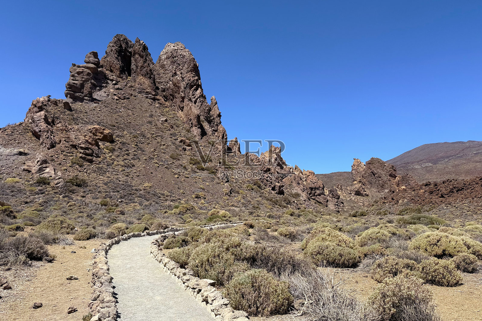 泰德国家公园，特内里费岛，罗克斯德加西亚的崎岖地貌，一条蜿蜒的小路穿过干枯的植被照片摄影图片
