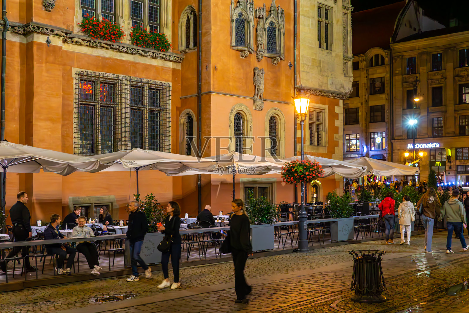 夜色中弗罗茨瓦夫市政厅墙边的餐厅露台照片摄影图片