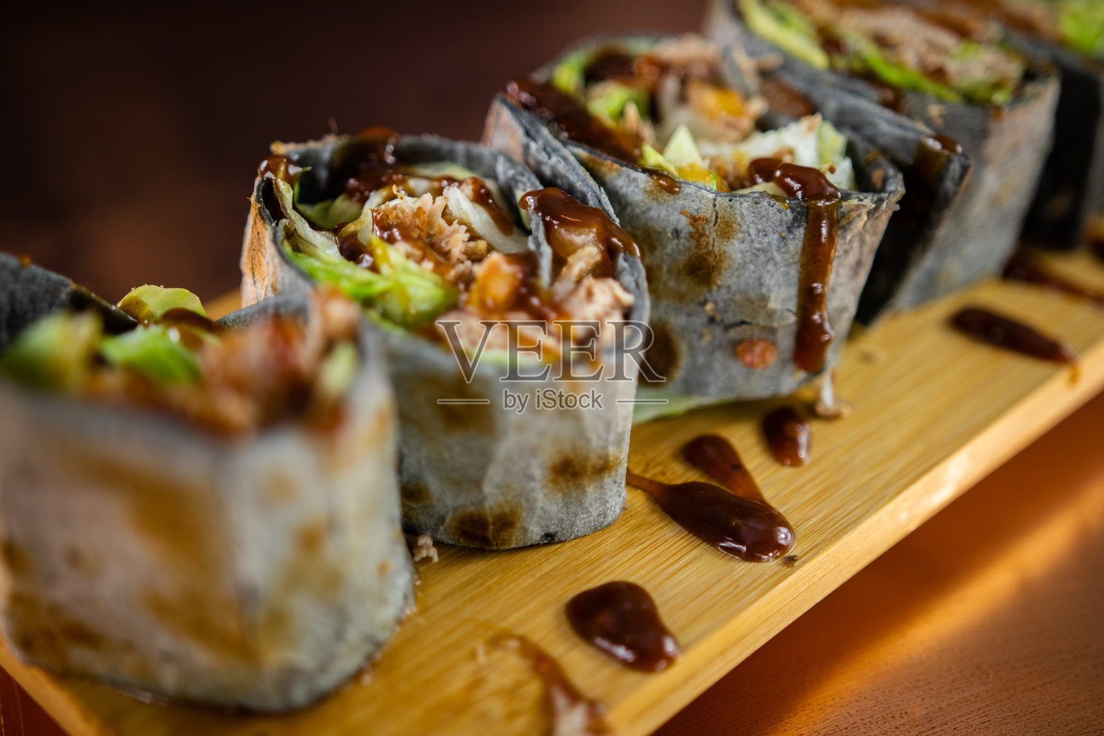 半切卷饼，内含生牛肉末、新鲜生菜和奶油芥末酱，置于乡村木质表面上，高分辨率美食摄影照片摄影图片