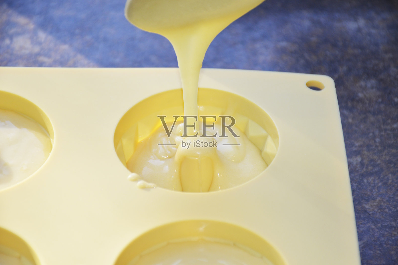 将松饼糊倒入硅胶烘焙模具照片摄影图片