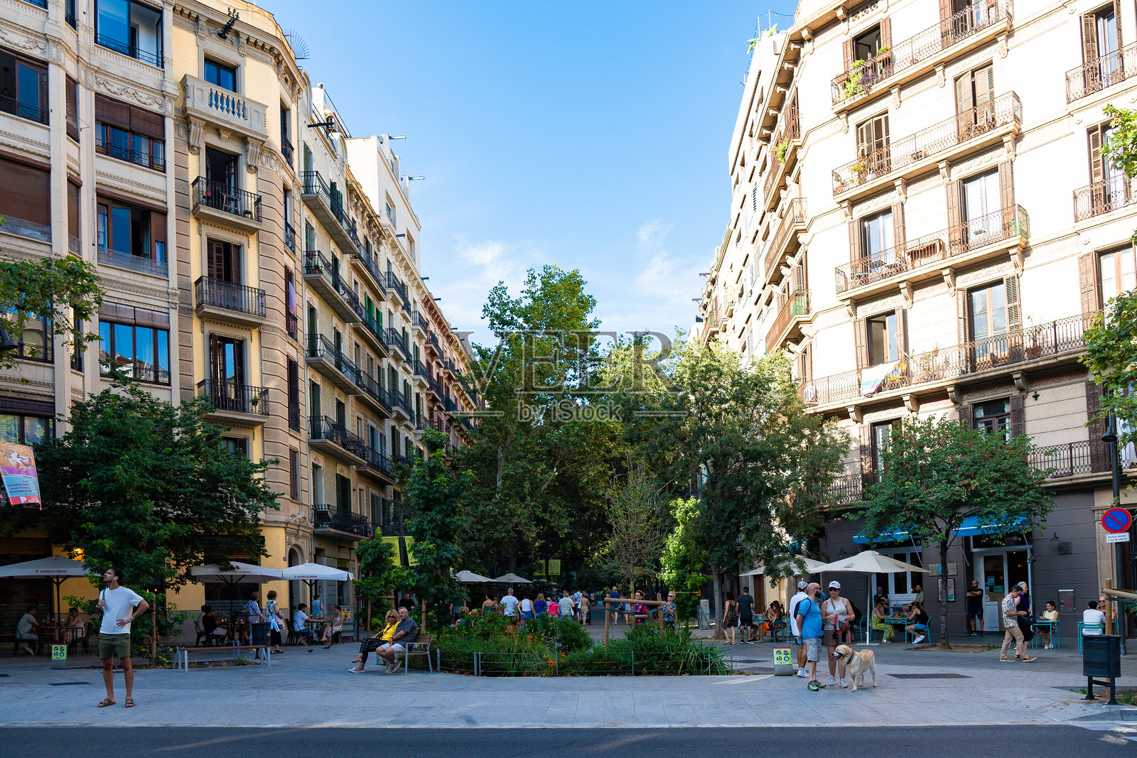 旅行者和当地人在公寓楼之间的区域享受白天的埃夏普勒区（Eixample）照片摄影图片