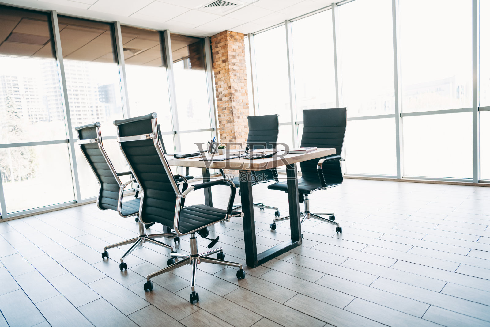 阳光明媚的公司办公室，设有行政办公桌和椅子，可欣赏城市景观，营造出现代优雅的工作空间。照片摄影图片
