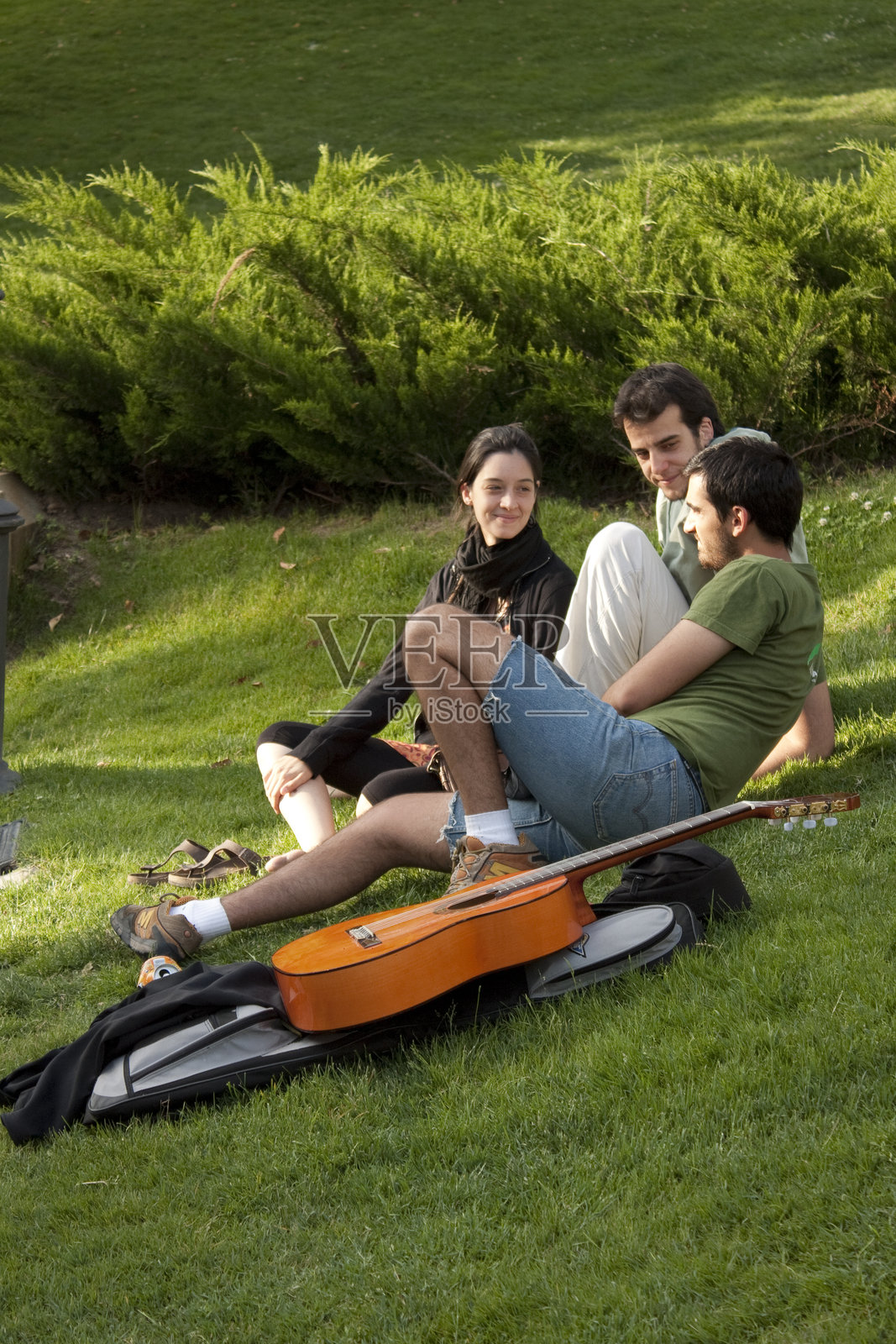 年轻的朋友们在马德里公园弹吉他放松照片摄影图片