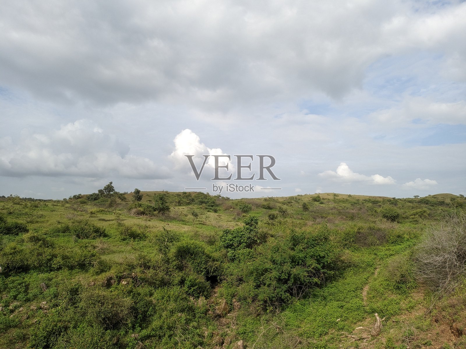 多云蓝天下的山地景观照片摄影图片