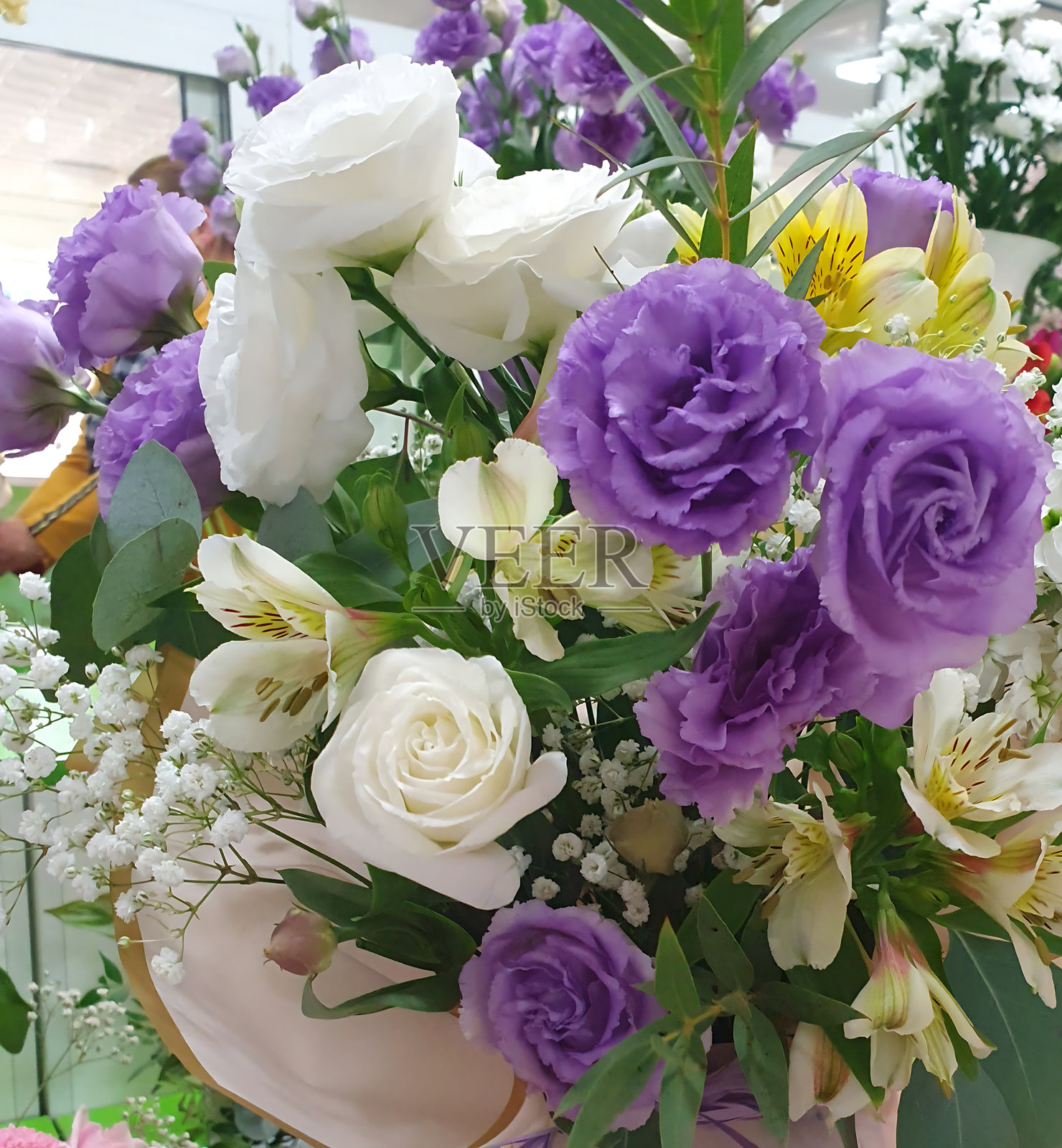 一束迷人的花束，将优雅的白色和浓郁的蓝色洋桔梗与其他娇嫩的花朵巧妙搭配。照片摄影图片