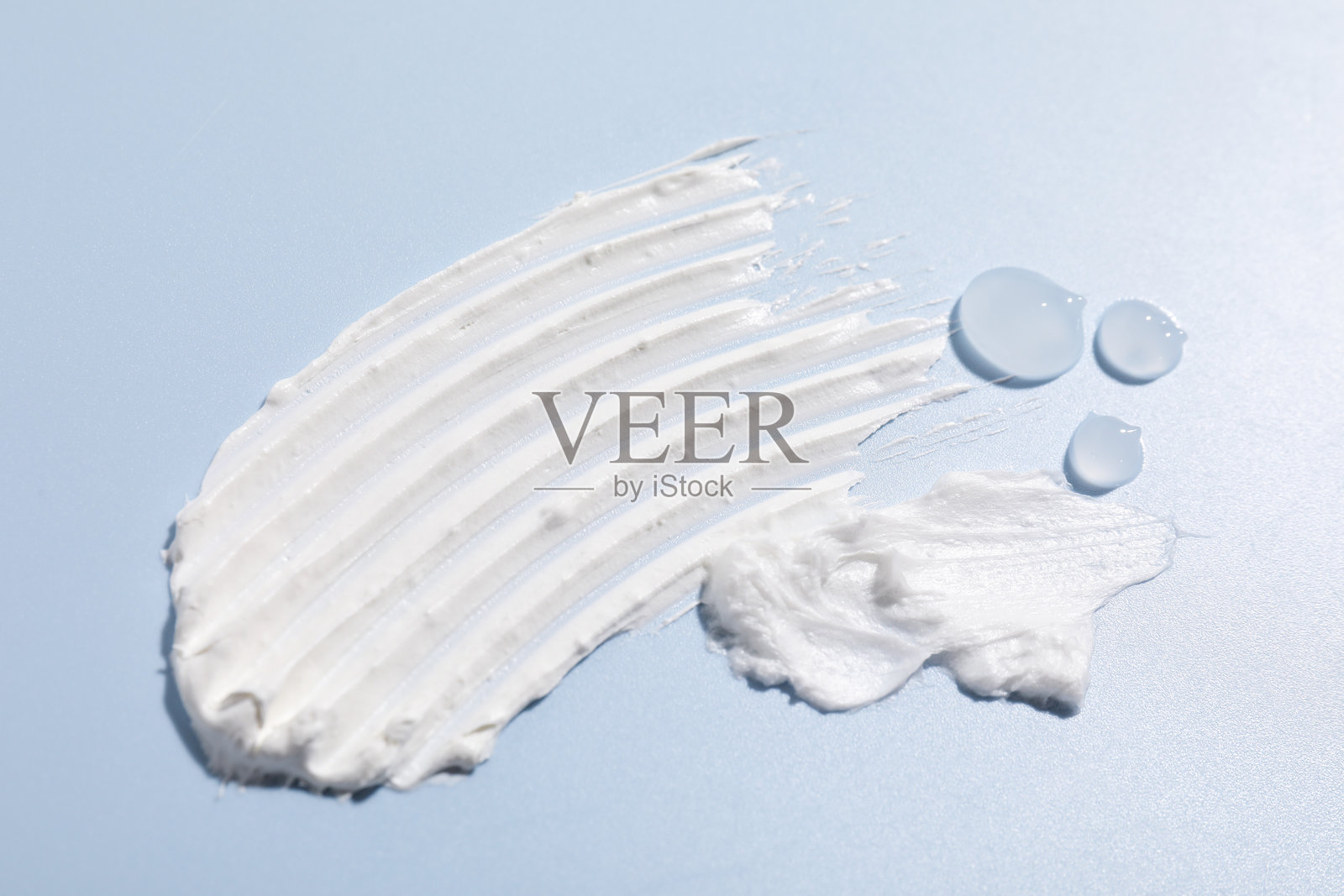 浅蓝色背景下的不同化妆品，特写照片摄影图片