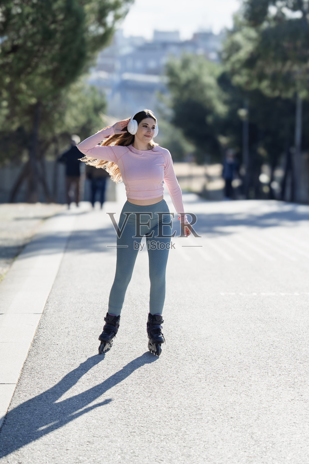 年轻女子在公园滑旱冰，享受阳光明媚的一天照片摄影图片
