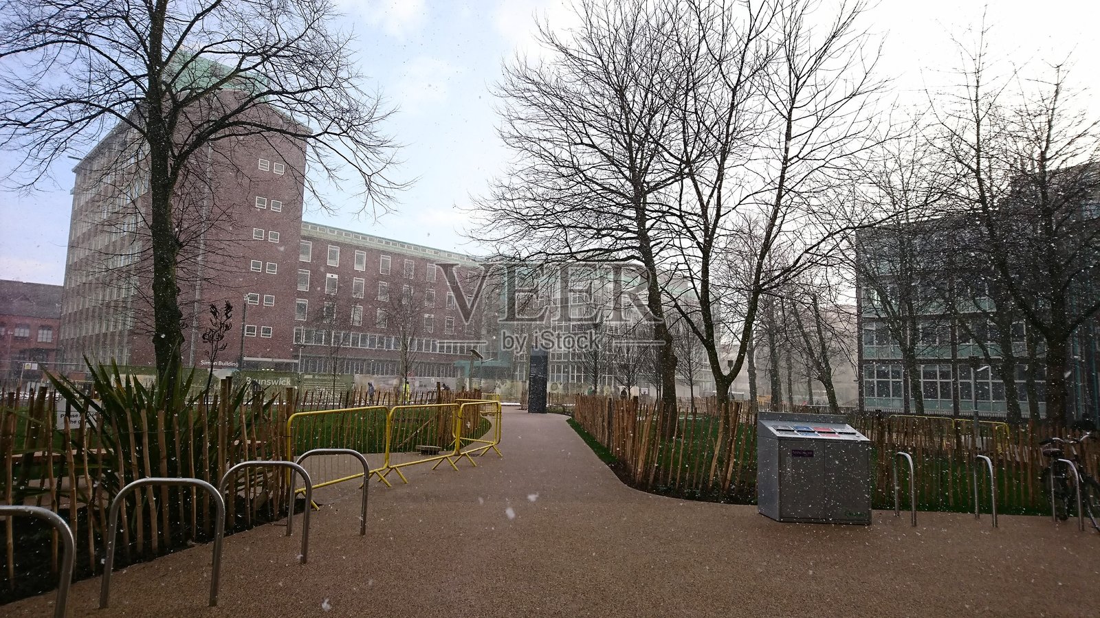 寒冷冬日，曼彻斯特大学校园和布伦瑞克公园飘落着小雪。照片摄影图片
