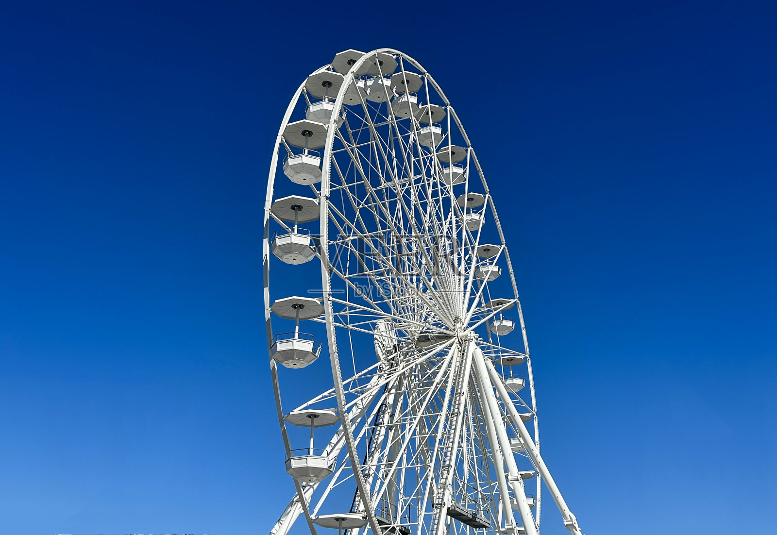 蓝天映衬下的白色摩天轮。照片摄影图片