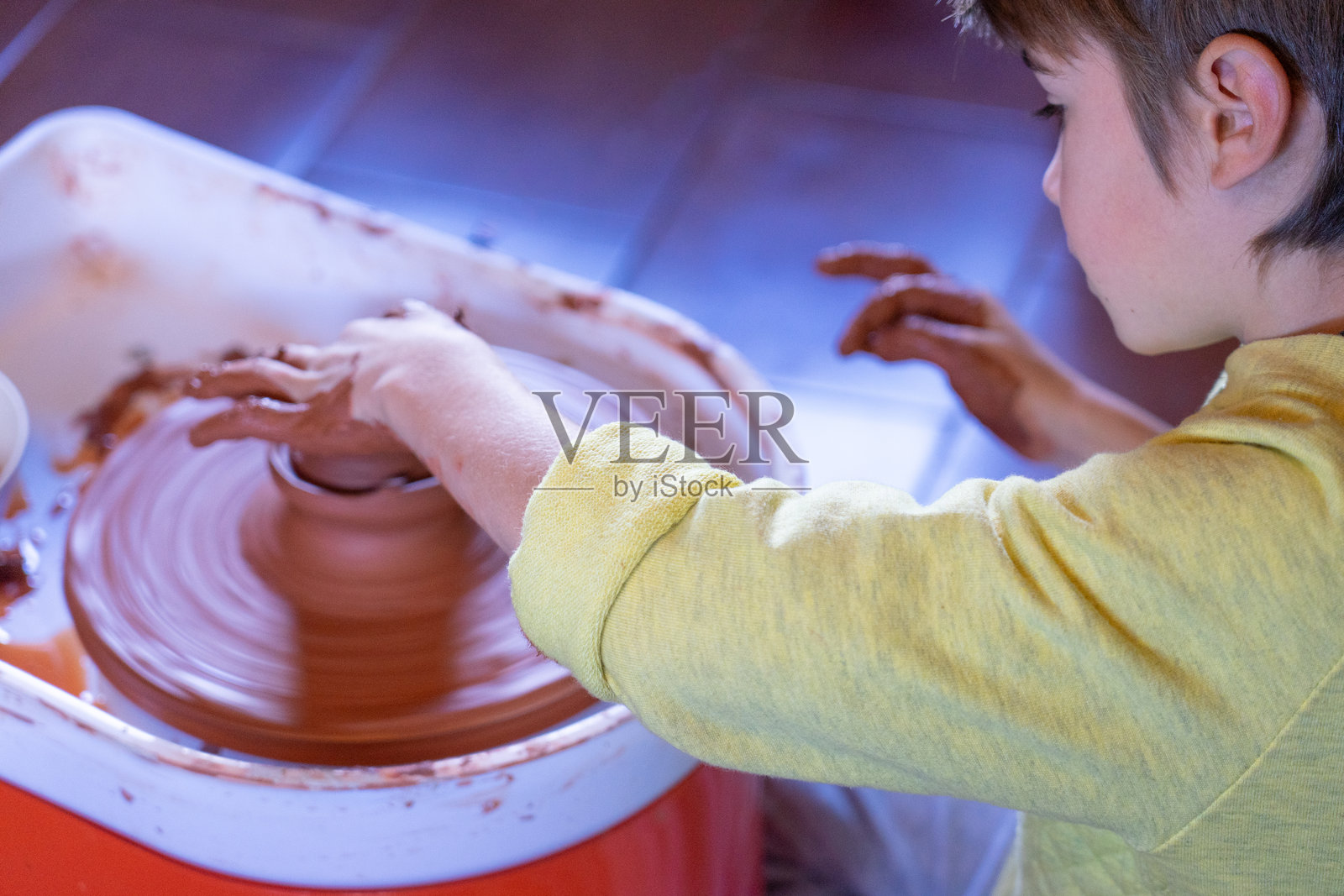 孩子在陶轮上制作陶罐照片摄影图片