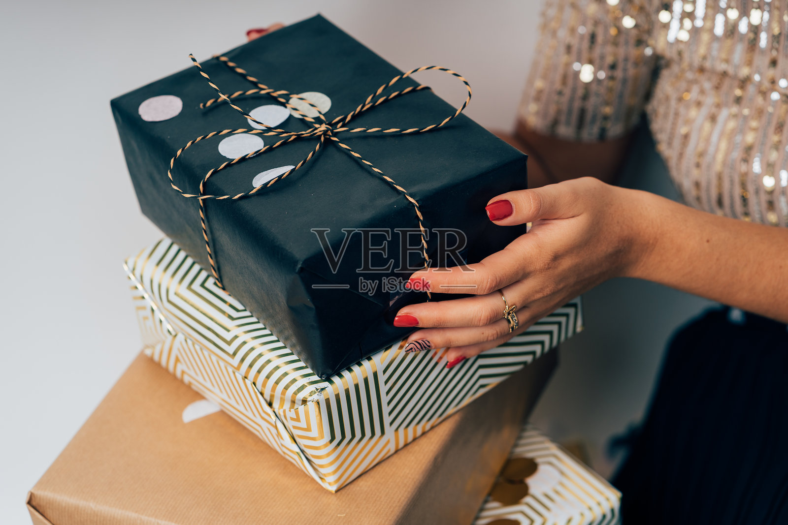 女人双手捧着一叠包装精美的圣诞礼物照片摄影图片