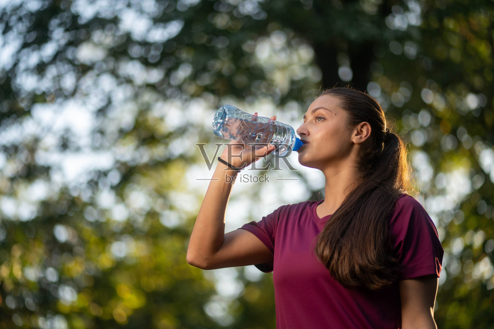 正在喝水的健身跑步女运动员照片摄影图片
