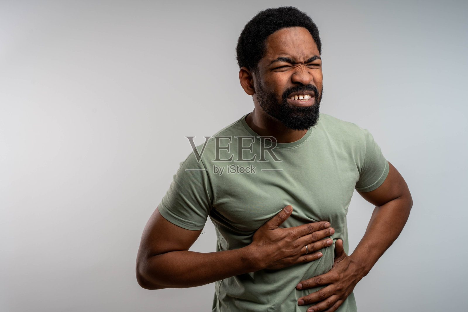 一名男子在家中因剧烈腹痛而痛苦地坐着。照片摄影图片