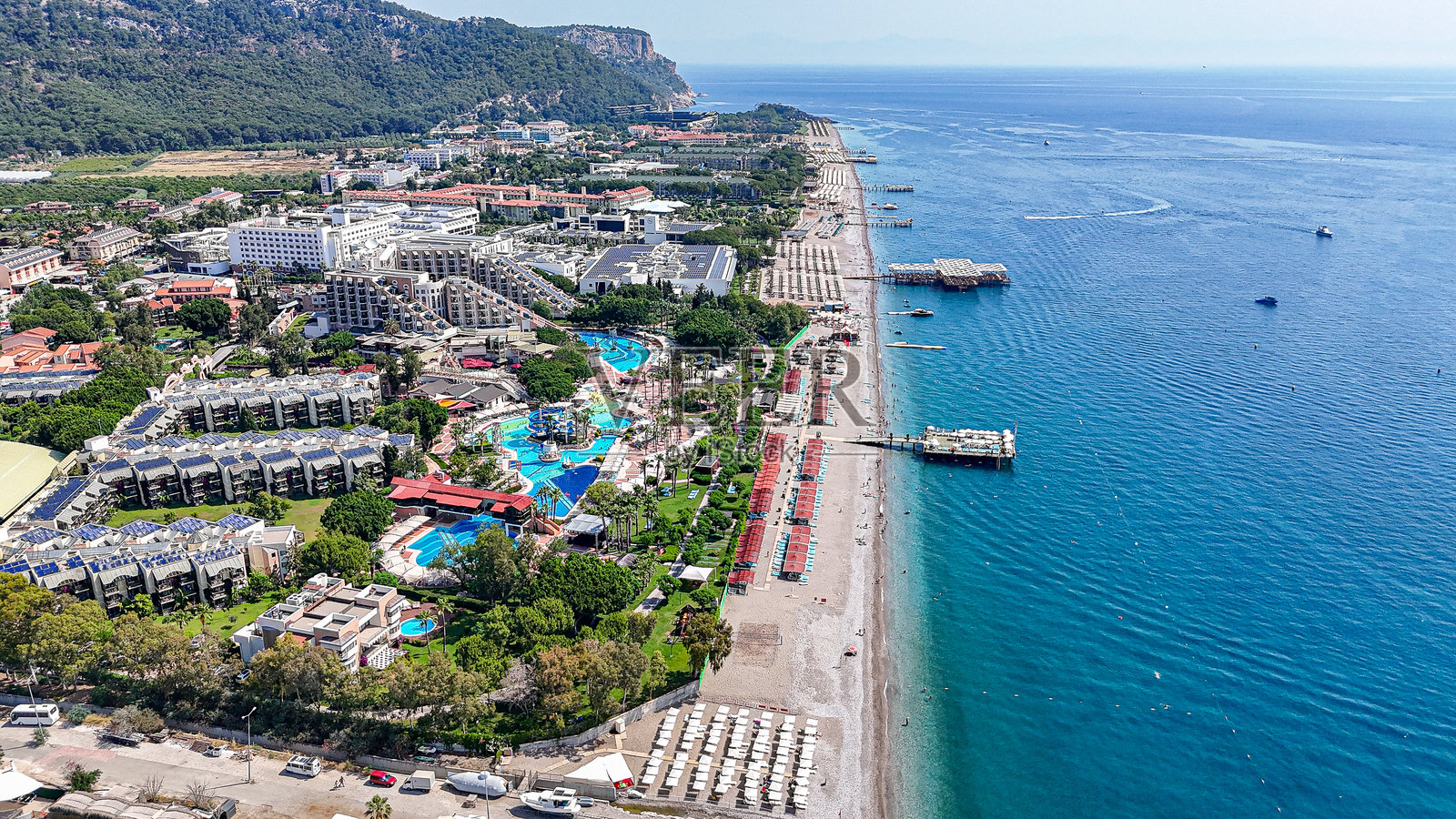 凯梅尔·基里斯度假中心的海岸线、沙滩遮阳伞和码头的鸟瞰图照片摄影图片