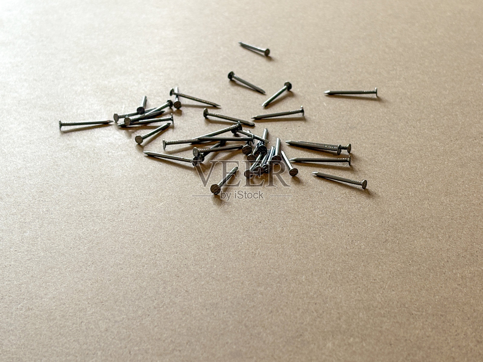 木质背景上的建筑钉子。木工工具钉子在棕色木质表面上。照片摄影图片