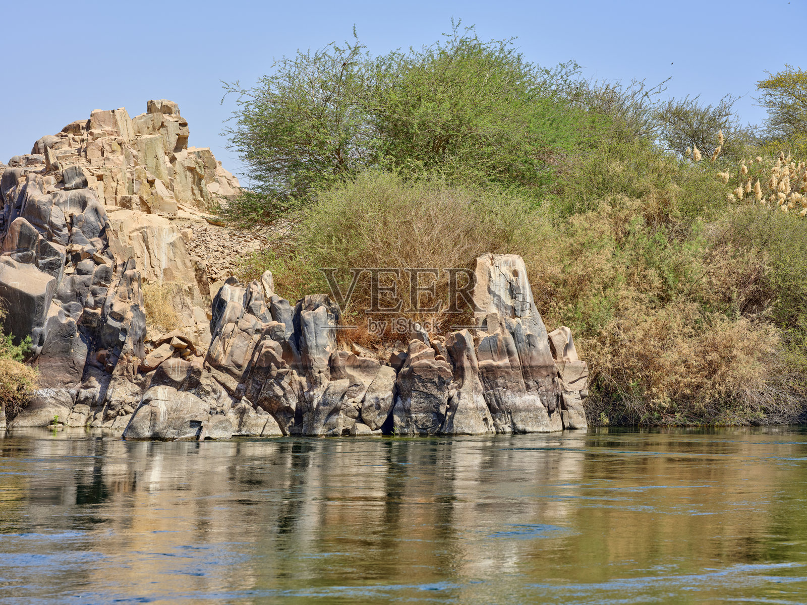 碧空下的尼罗河畔风景，河岸岩石嶙峋照片摄影图片