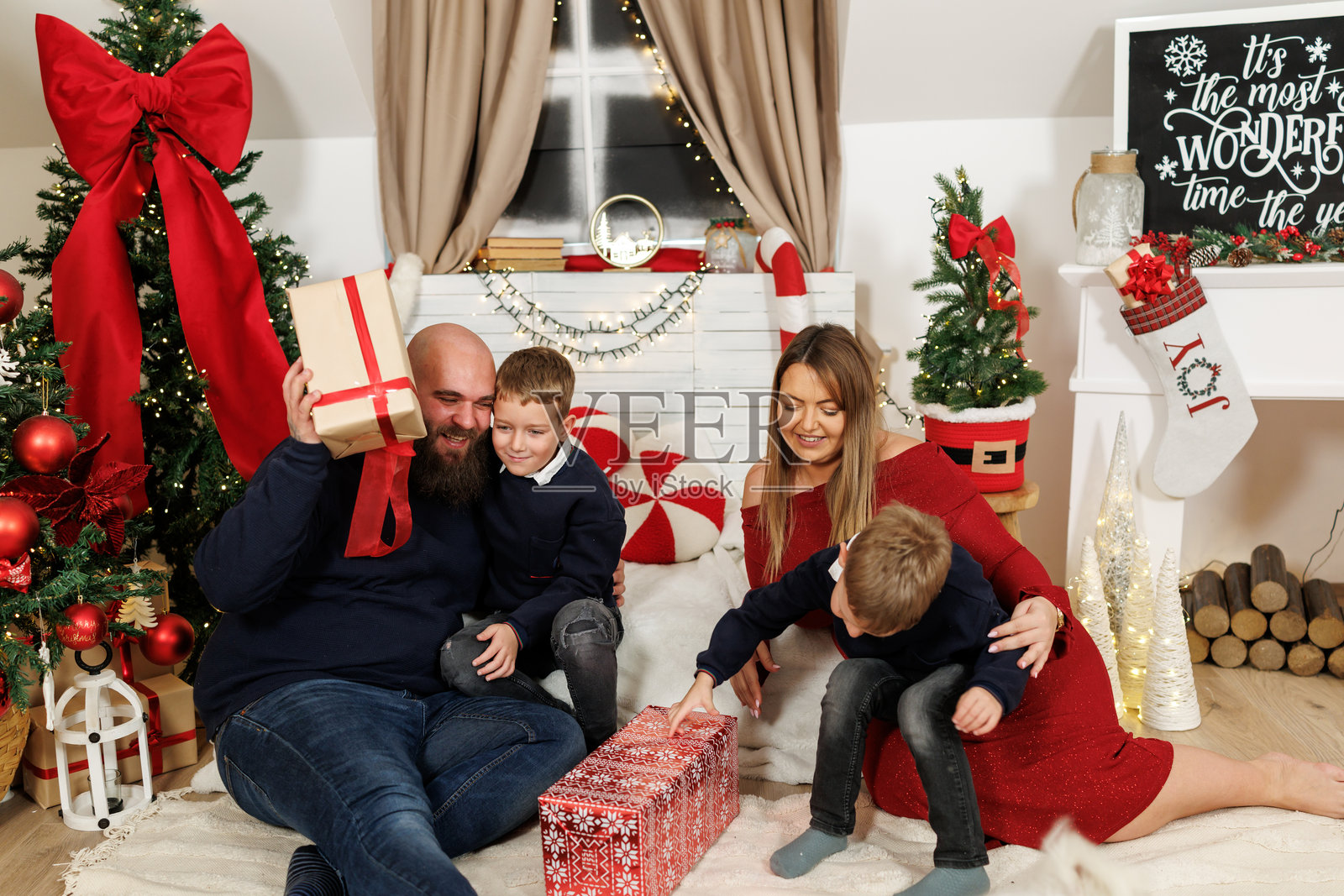 快乐的家人在家中坐在地板上交换圣诞礼物，特写肖像照片摄影图片