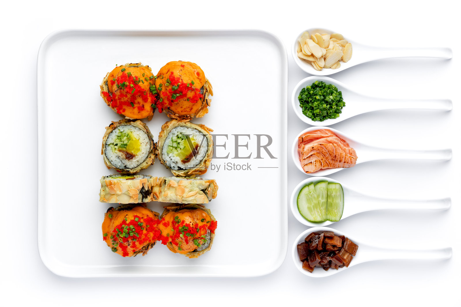 精致的寿司卷盛放在白盘中，背景为纯白色，寿司配料分别装在白色勺子里，独立摆放。照片摄影图片
