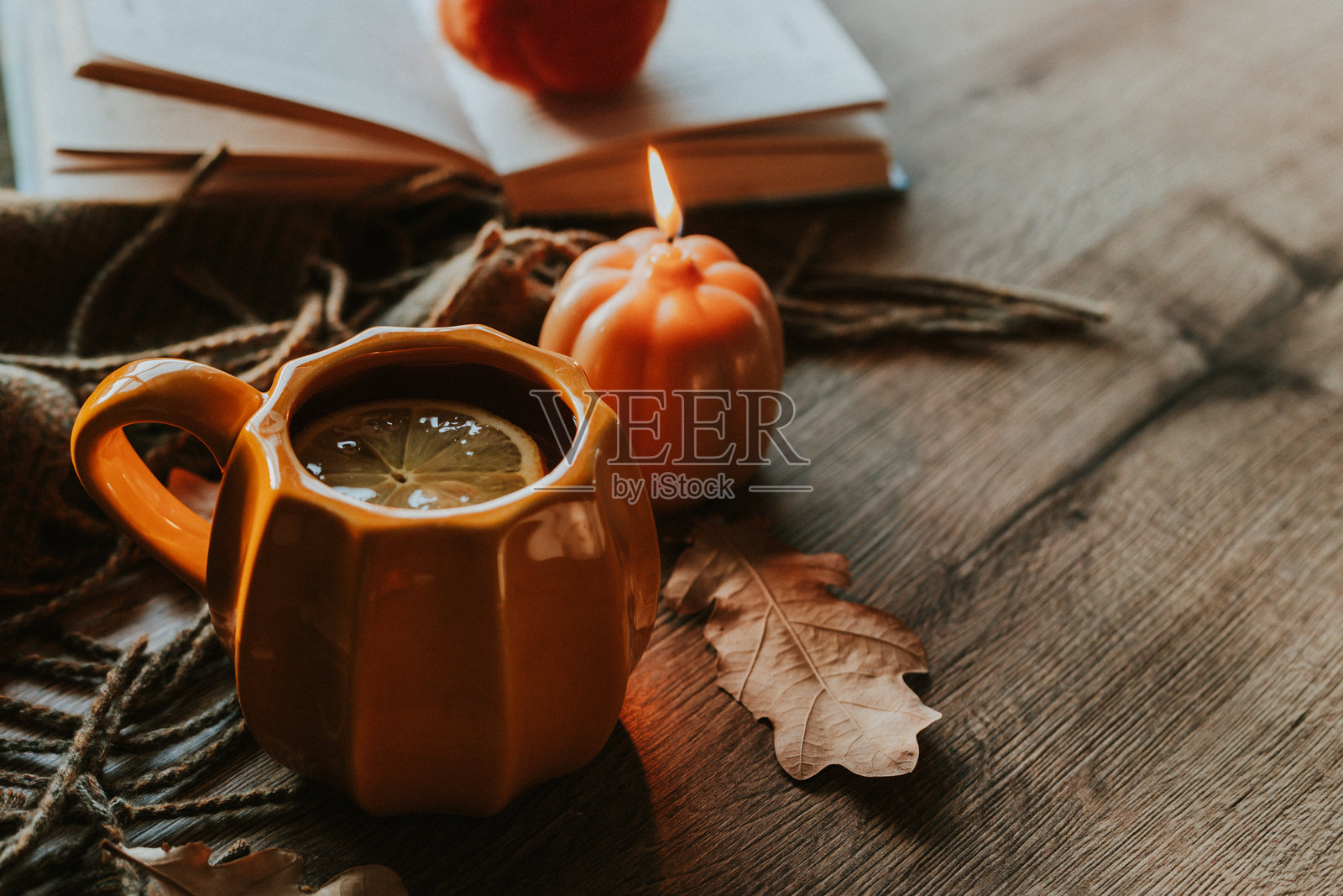 舒适的秋季场景，配有热饮、打开的书籍和南瓜装饰照片摄影图片