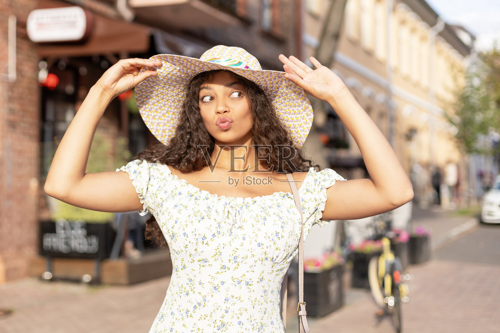 一位穿着夏季嬉皮士服装的漂亮、爱笑的棕发模特。一位风趣、积极的女性正在玩乐。照片摄影图片