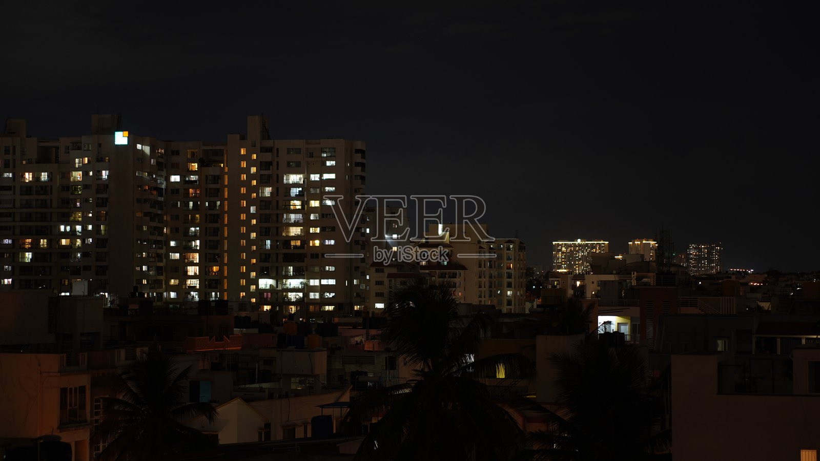 黄昏时分，城市中高层住宅楼灯火辉煌，与天空相映成趣。照片摄影图片