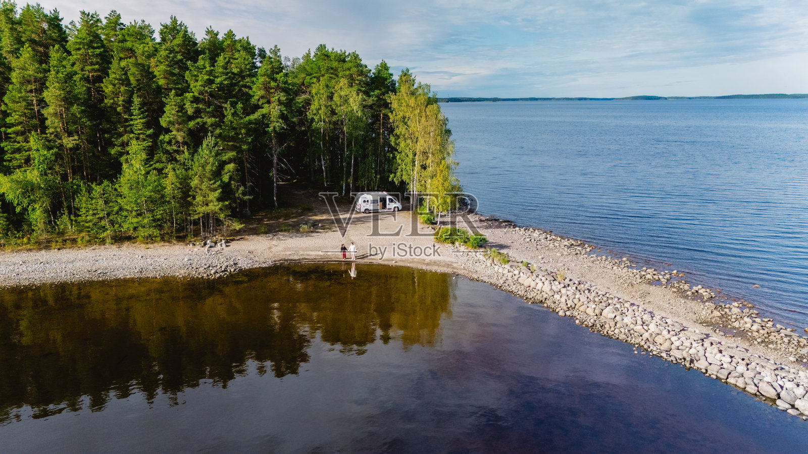 芬兰塞马湖畔宁静的夏日度假，旁边停着一辆露营车照片摄影图片