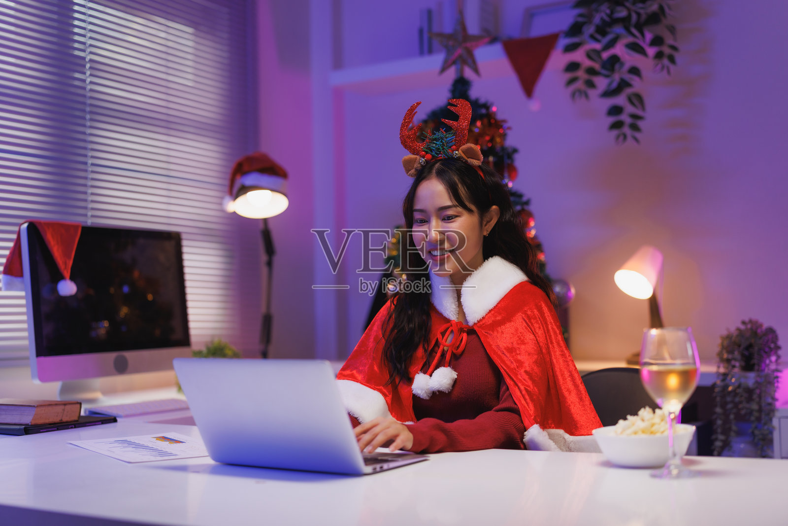年轻女子通过笔记本电脑享受在线虚拟圣诞派对照片摄影图片