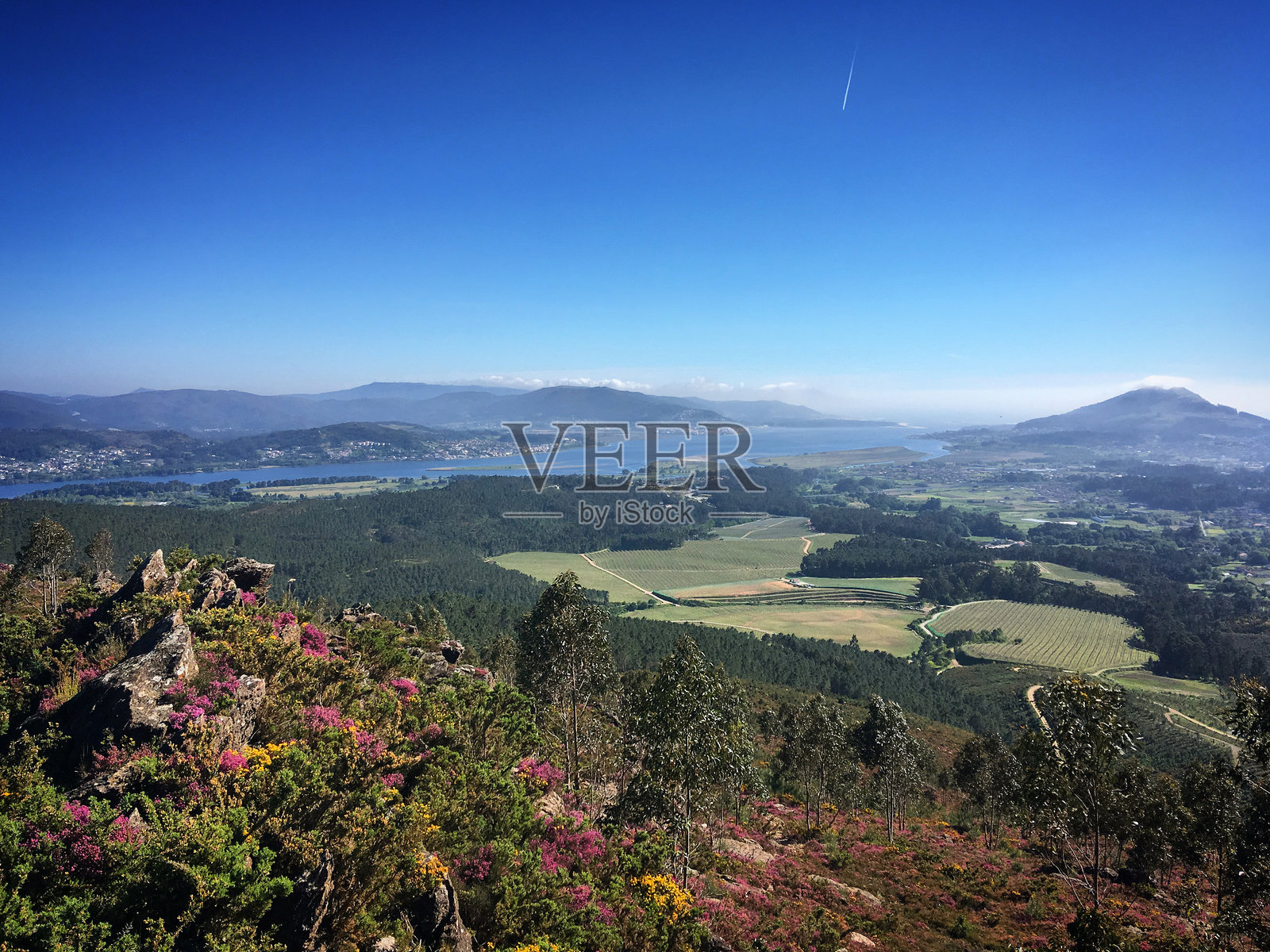 加利西亚奥罗萨尔，西班牙，2019年4月，米尼奥河与海洋沿岸景观的风景，背景是山脉，天空湛蓝。照片摄影图片