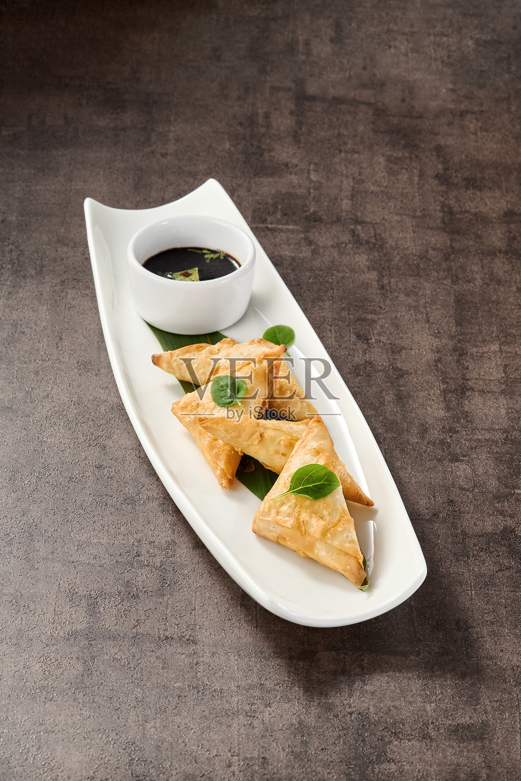 白盘子里的蟹肉酥皮点心，明亮的灯光，极简的俯视构图照片摄影图片