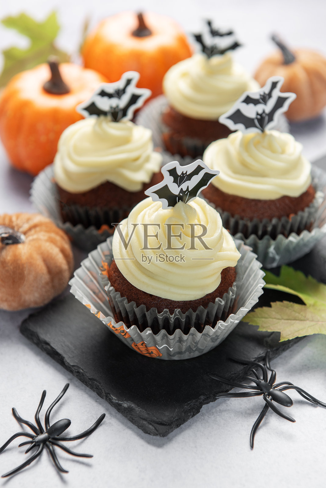 万圣节纸杯蛋糕，配有蝙蝠装饰和南瓜装饰照片摄影图片