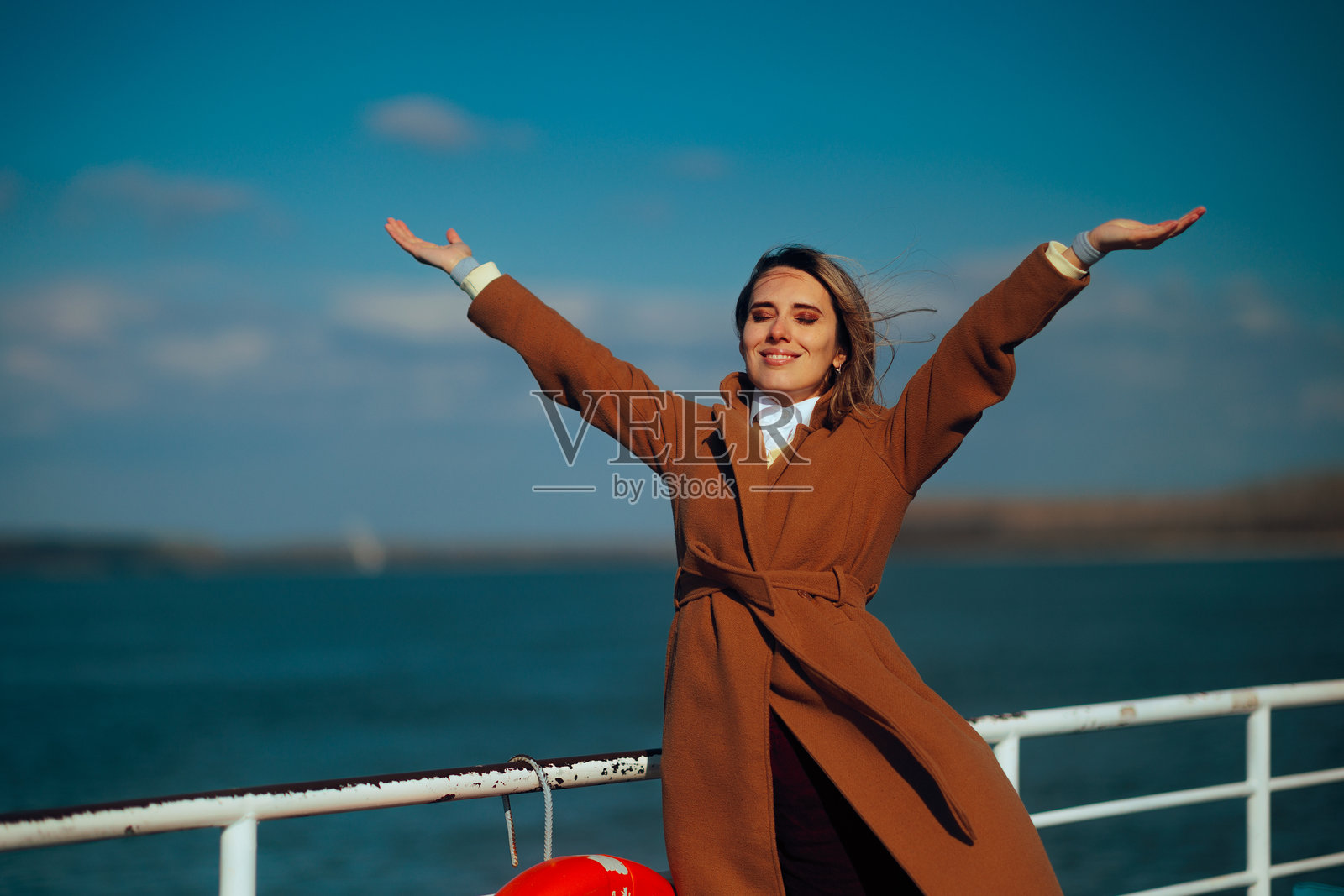 一位无忧无虑的女士在渡轮上享受新鲜空气，享受旅途。照片摄影图片