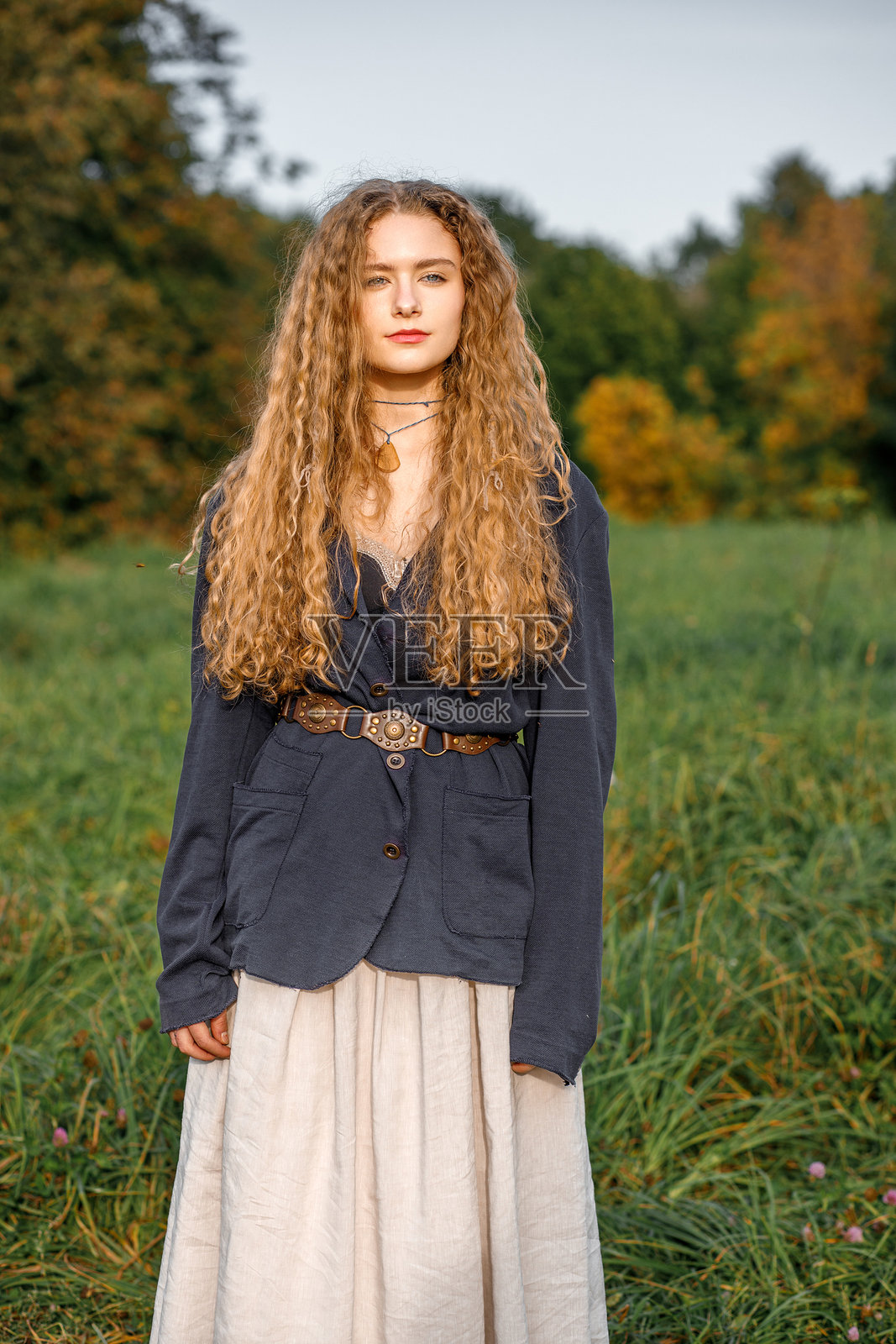 日落时分，时尚的嬉皮士年轻女子在自然背景下摆姿势拍照的肖像照照片摄影图片