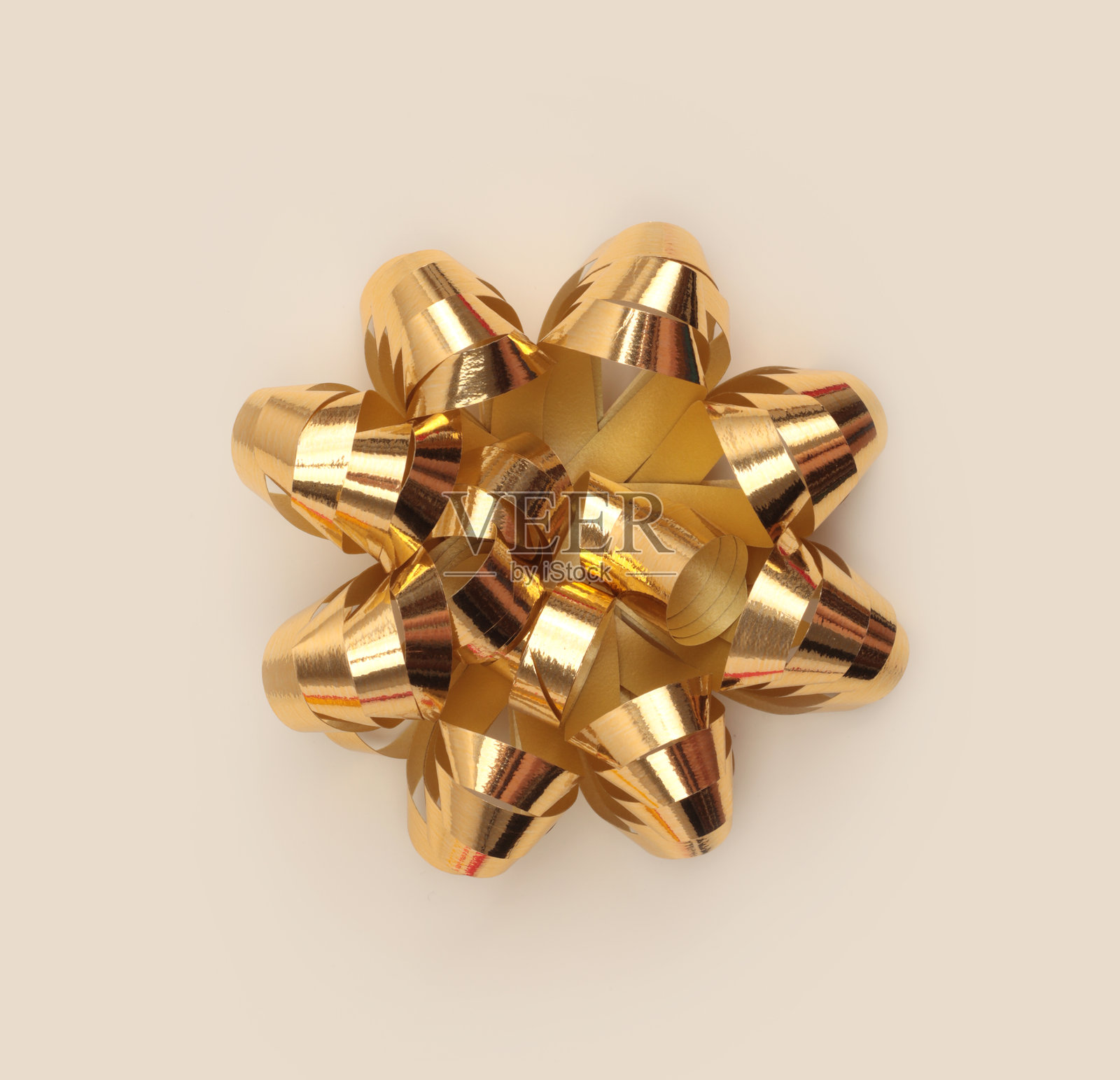 米灰色中性背景上带有光影的金色渐变色纸质丝带蝴蝶结。照片摄影图片