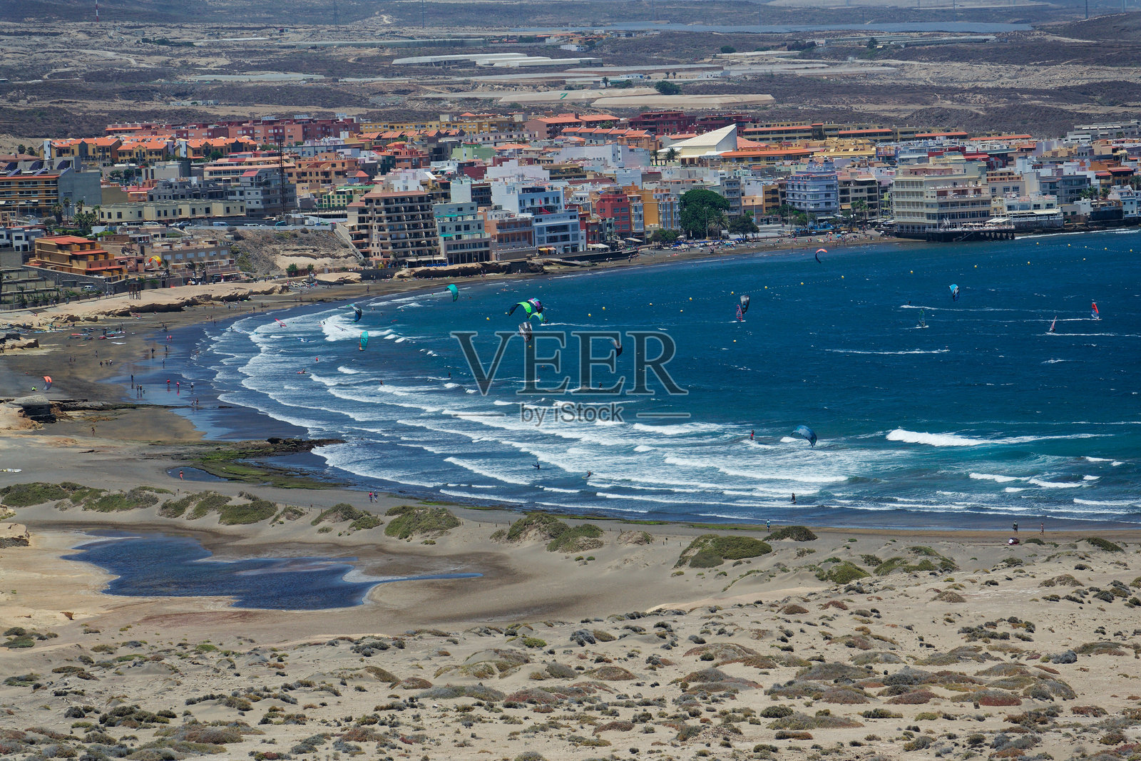 2019年7月9日，在西班牙埃尔梅达诺的格兰纳迪利亚德阿沃纳市的莱奥卡迪奥马查多海滩上，人们在冲浪、风筝冲浪和帆板冲浪。照片摄影图片