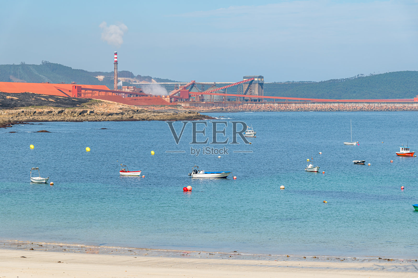 从西班牙锡夫劳港看到的景色，背景是美国铝业公司的制造工厂照片摄影图片