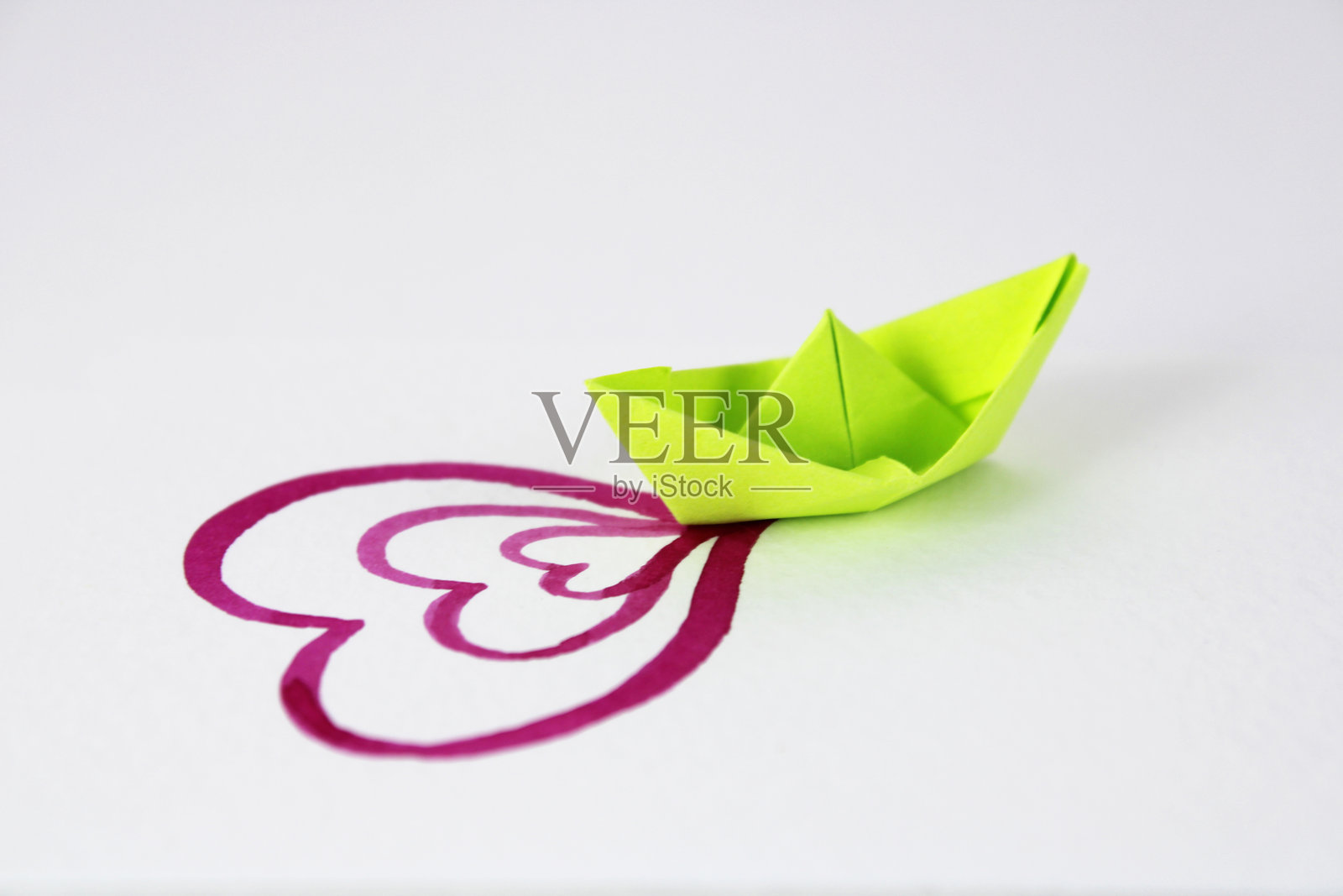 绿色船只在水中留下粉色爱心的轨迹照片摄影图片