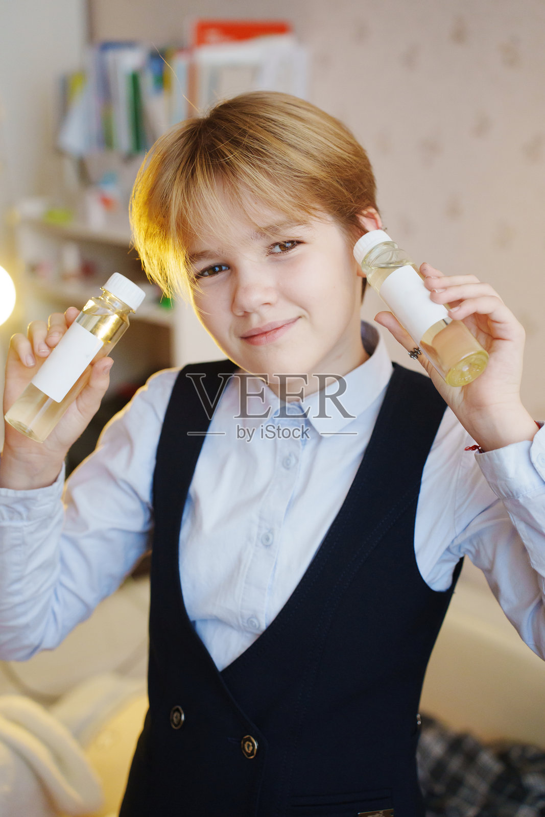舒适的室内环境中，孩子手持扩香器液体照片摄影图片