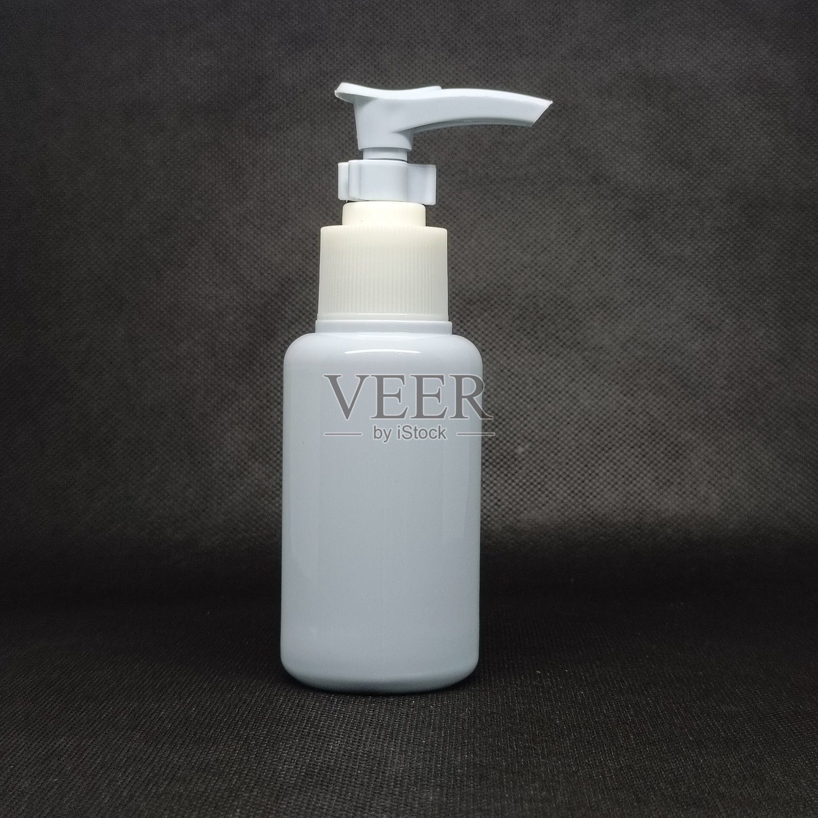 带有空白标签的化妆品瓶，背景为黑色照片摄影图片