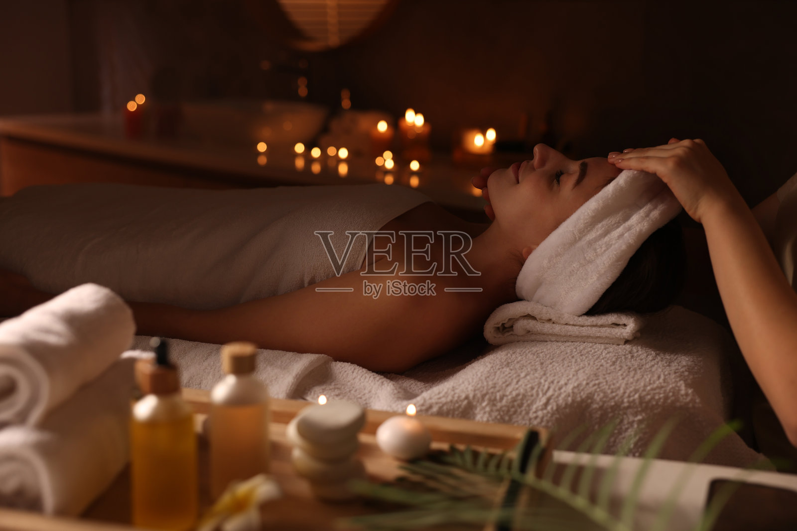 年轻女子在水疗沙龙接受按摩照片摄影图片