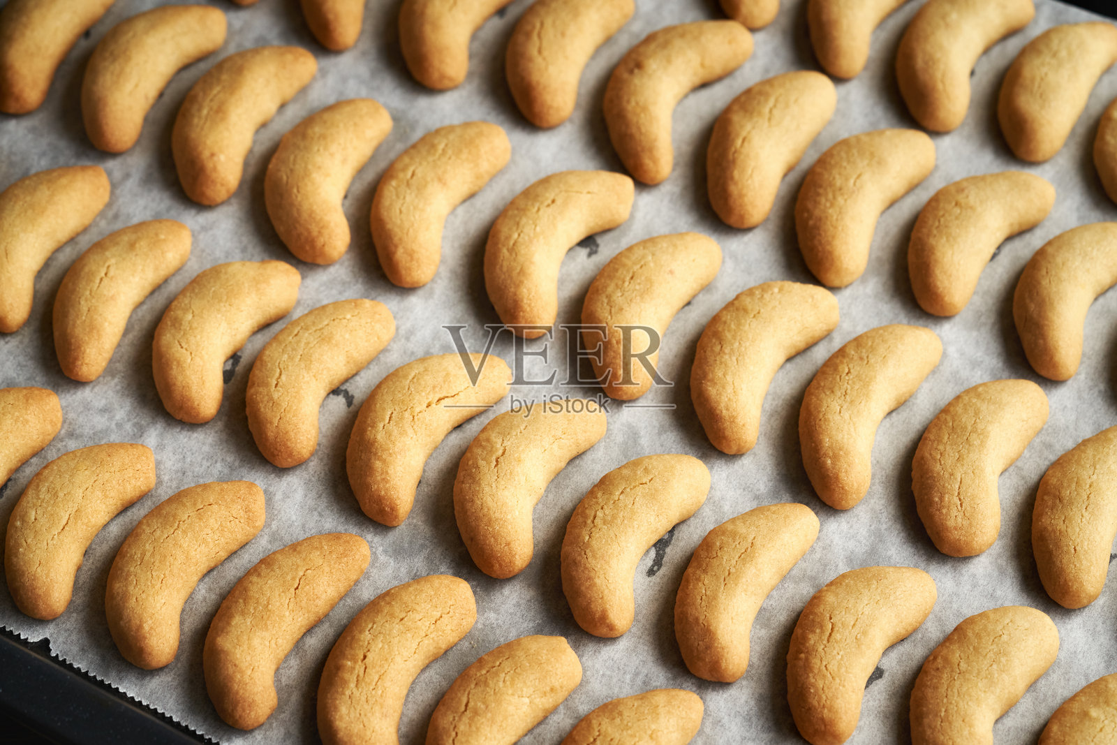 新鲜出炉的甜点心放在烤盘上——准备制作香草新月形饼干或传统的圣诞饼干Kipferl照片摄影图片