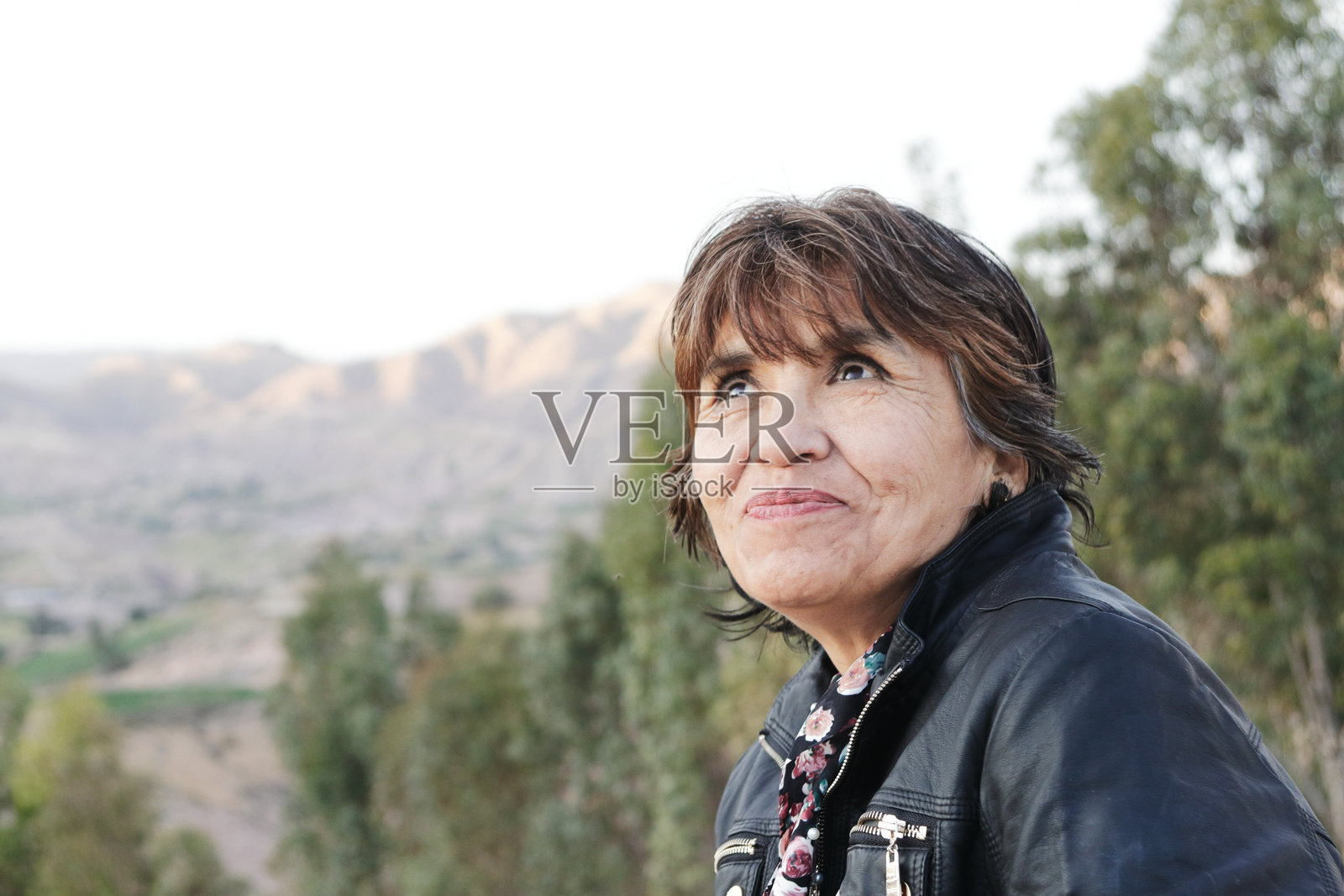 一位成熟的女探险家抬头欣赏山景照片摄影图片