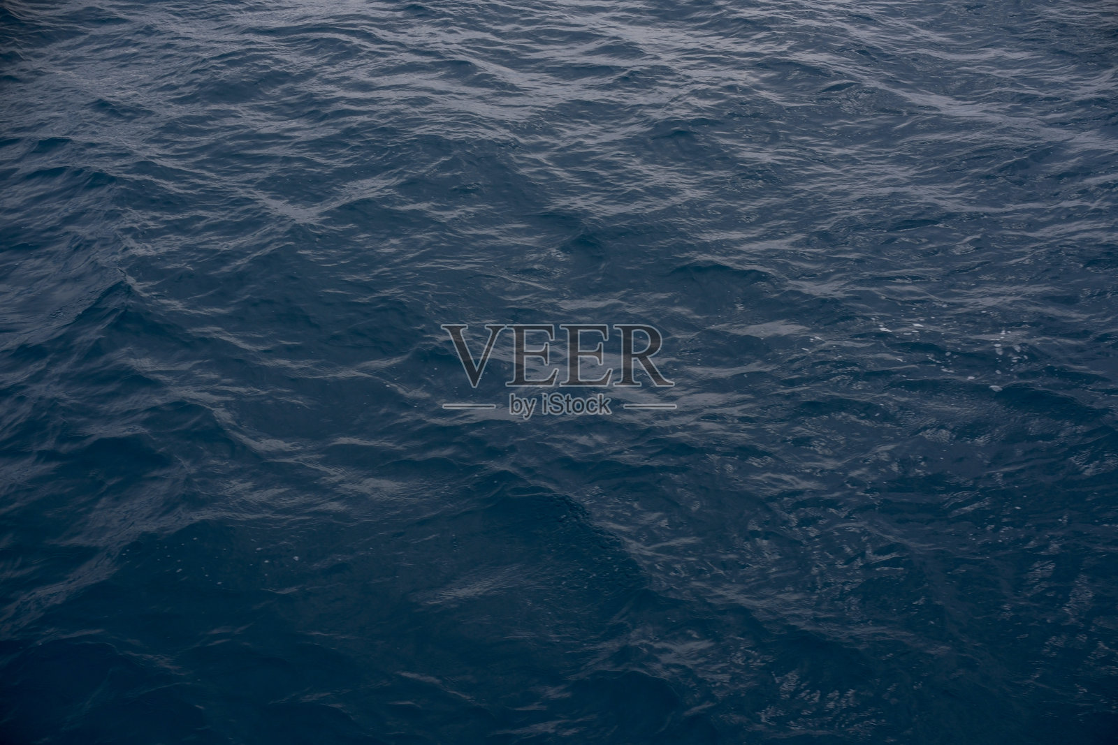 深邃忧郁的深蓝色海水纹理，带有细小的涟漪和波浪照片摄影图片