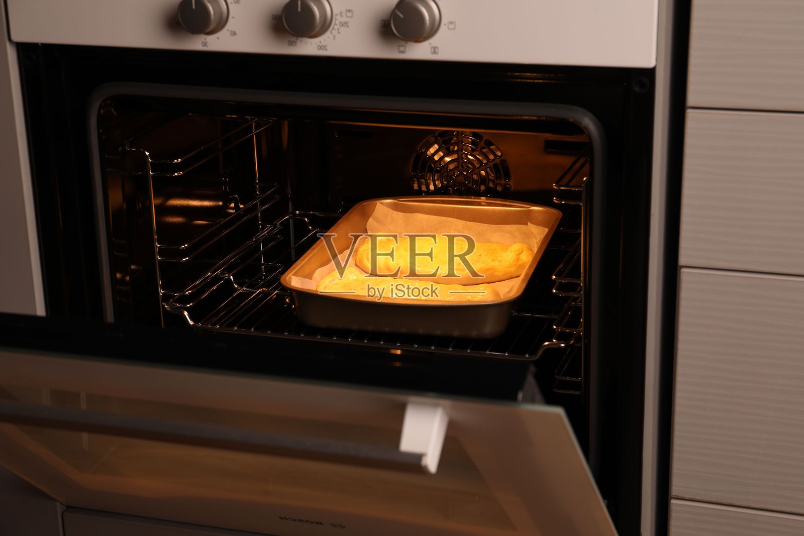 烤箱中的未烘烤的卡尔佐内披萨照片摄影图片