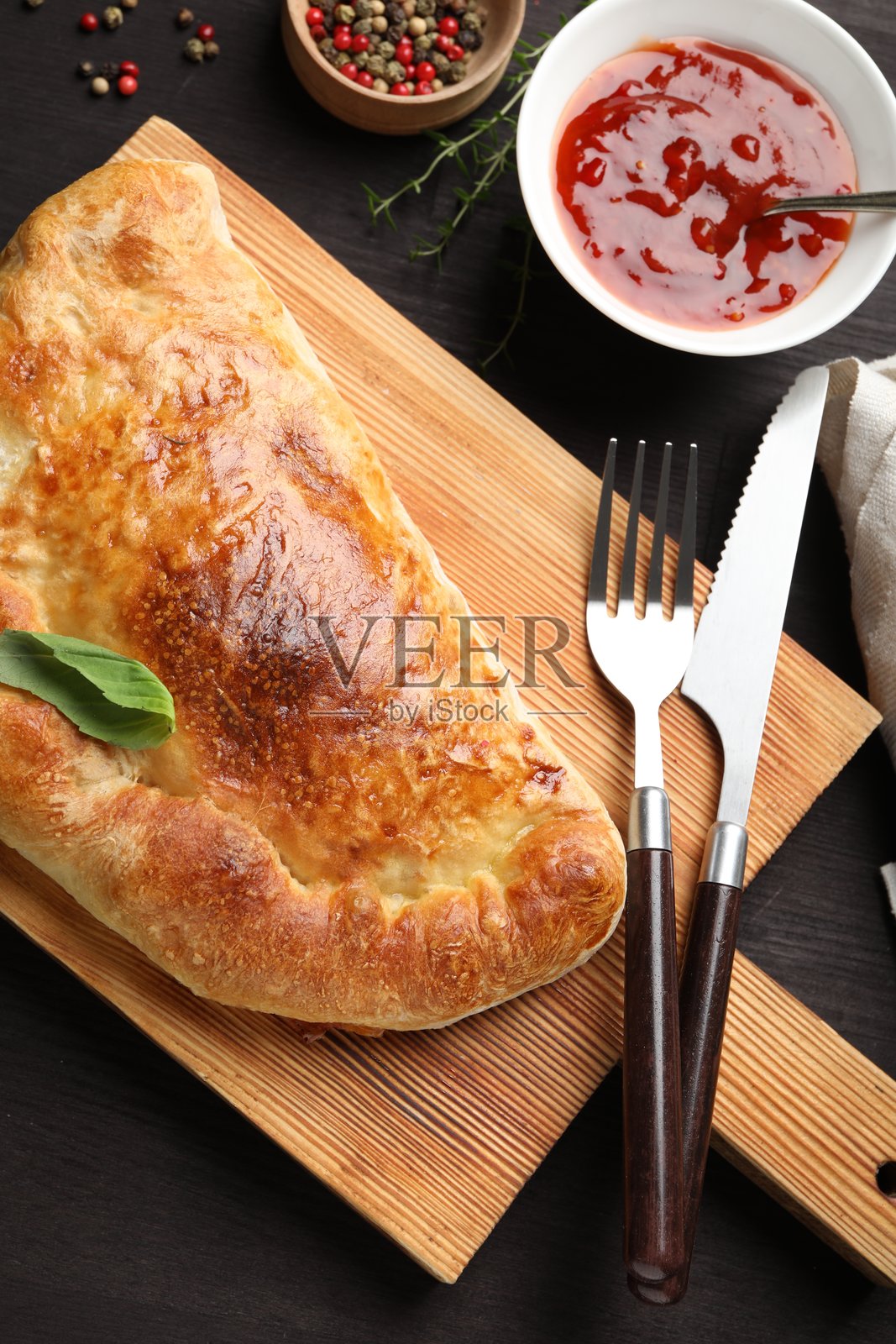 美味新鲜的卡尔佐内披萨，平铺在木桌上照片摄影图片