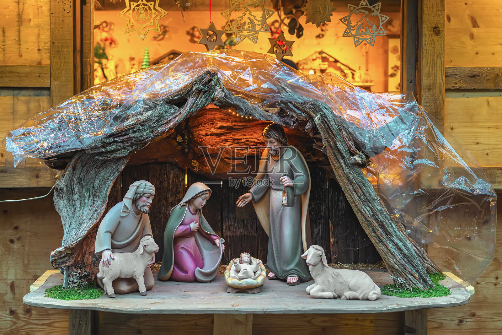 传统的耶稣诞生场景，约瑟、玛利亚、婴儿耶稣和动物在柔和灯光下的木制马槽里。象征着耶稣诞生、圣诞奇迹和精神庆典。照片摄影图片