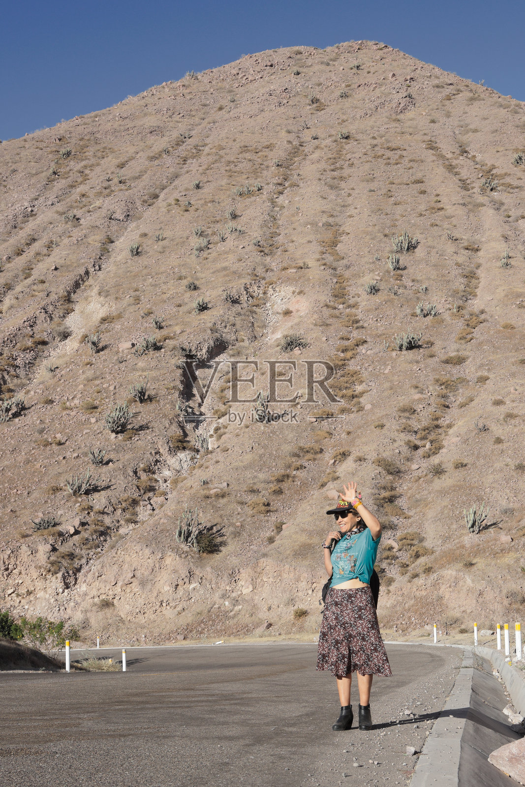 女探险家在沙漠公路上遮挡眼睛照片摄影图片