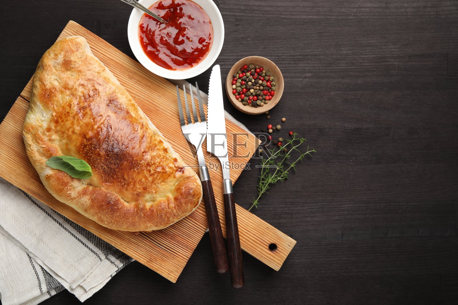 美味的现烤卡尔佐内披萨，平铺在木桌上，留有文字空间。照片摄影图片