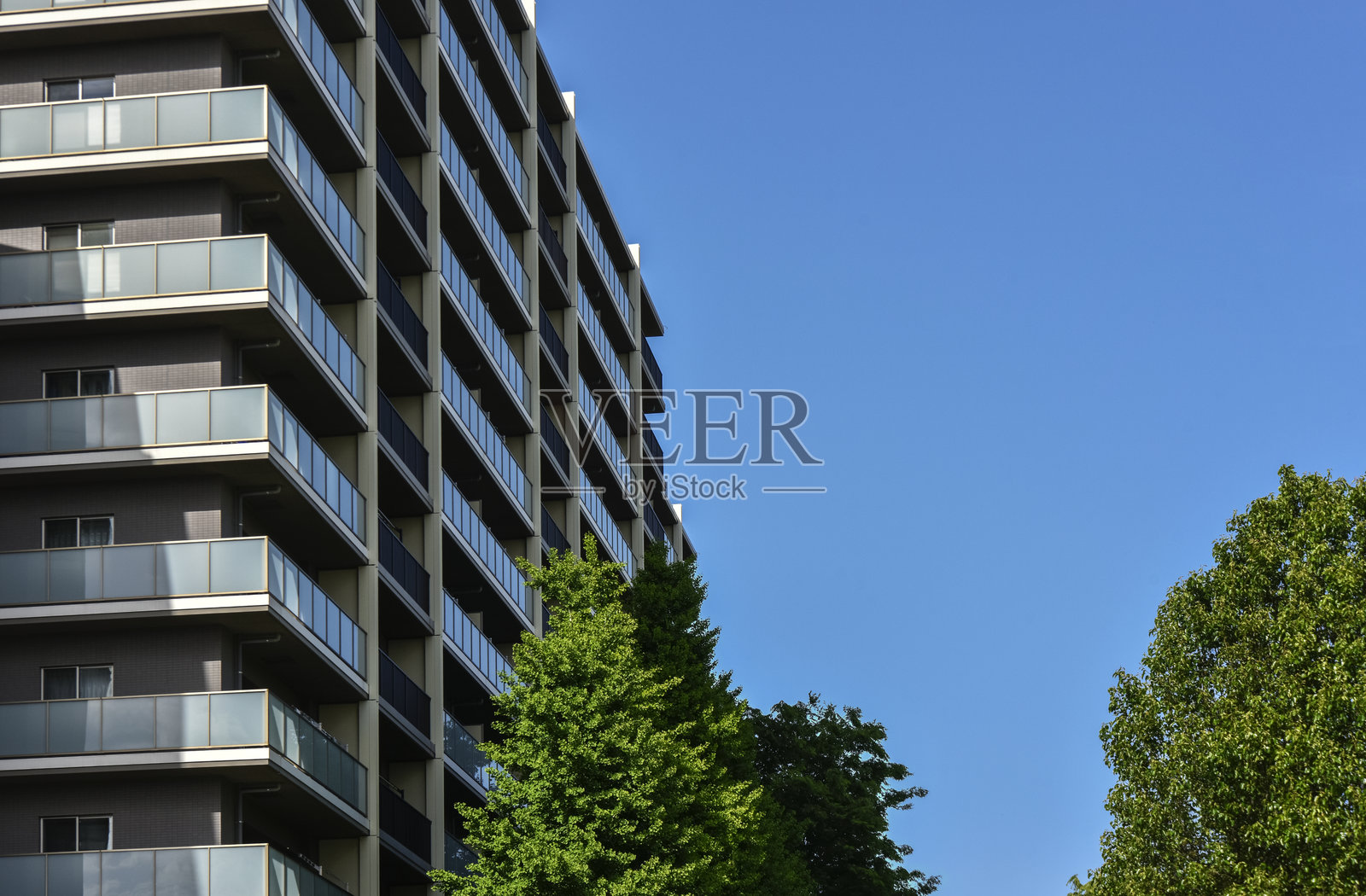 阳光明媚的日子里的一栋公寓楼。照片摄影图片