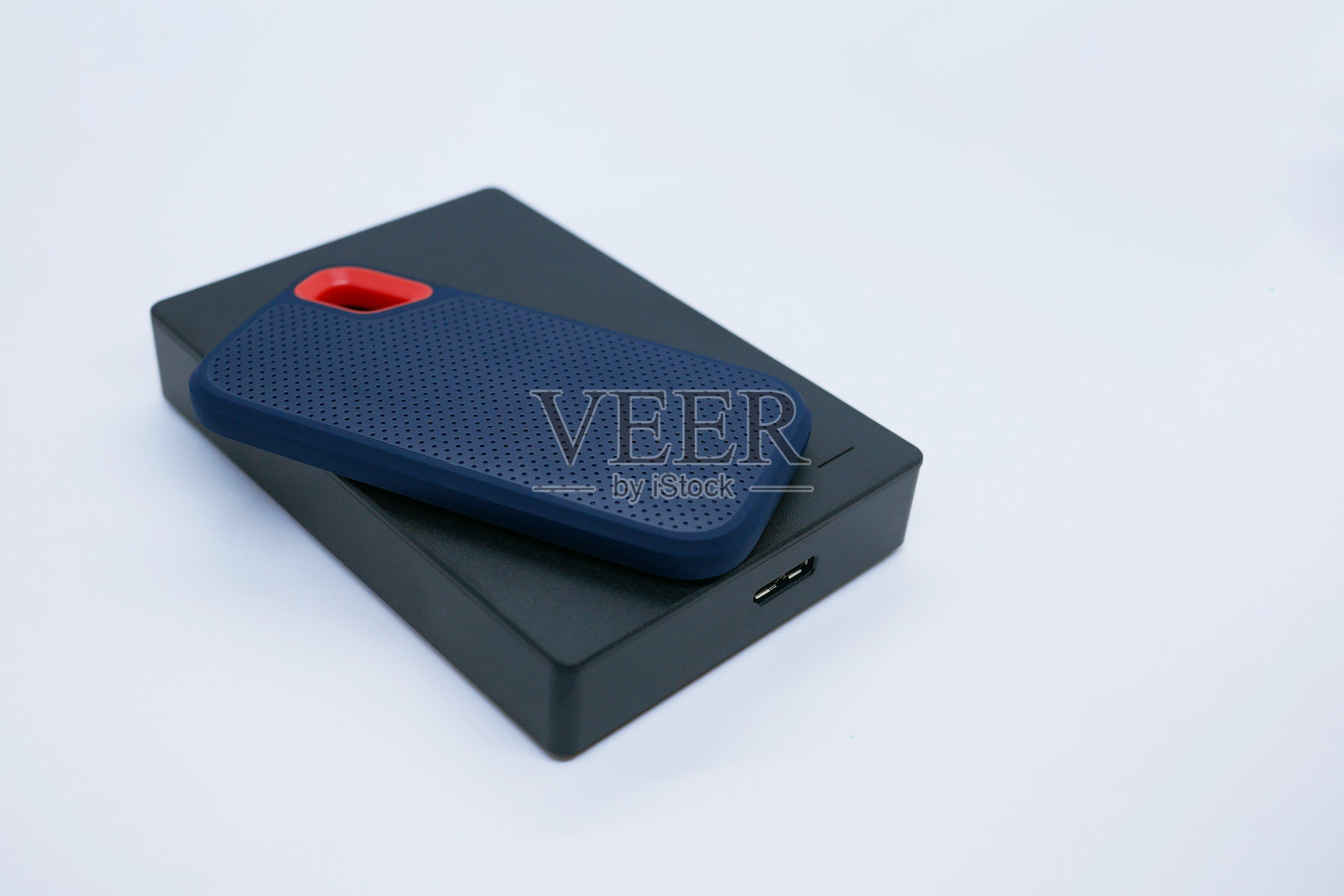 白色背景上的两个外置固态硬盘和机械硬盘照片摄影图片