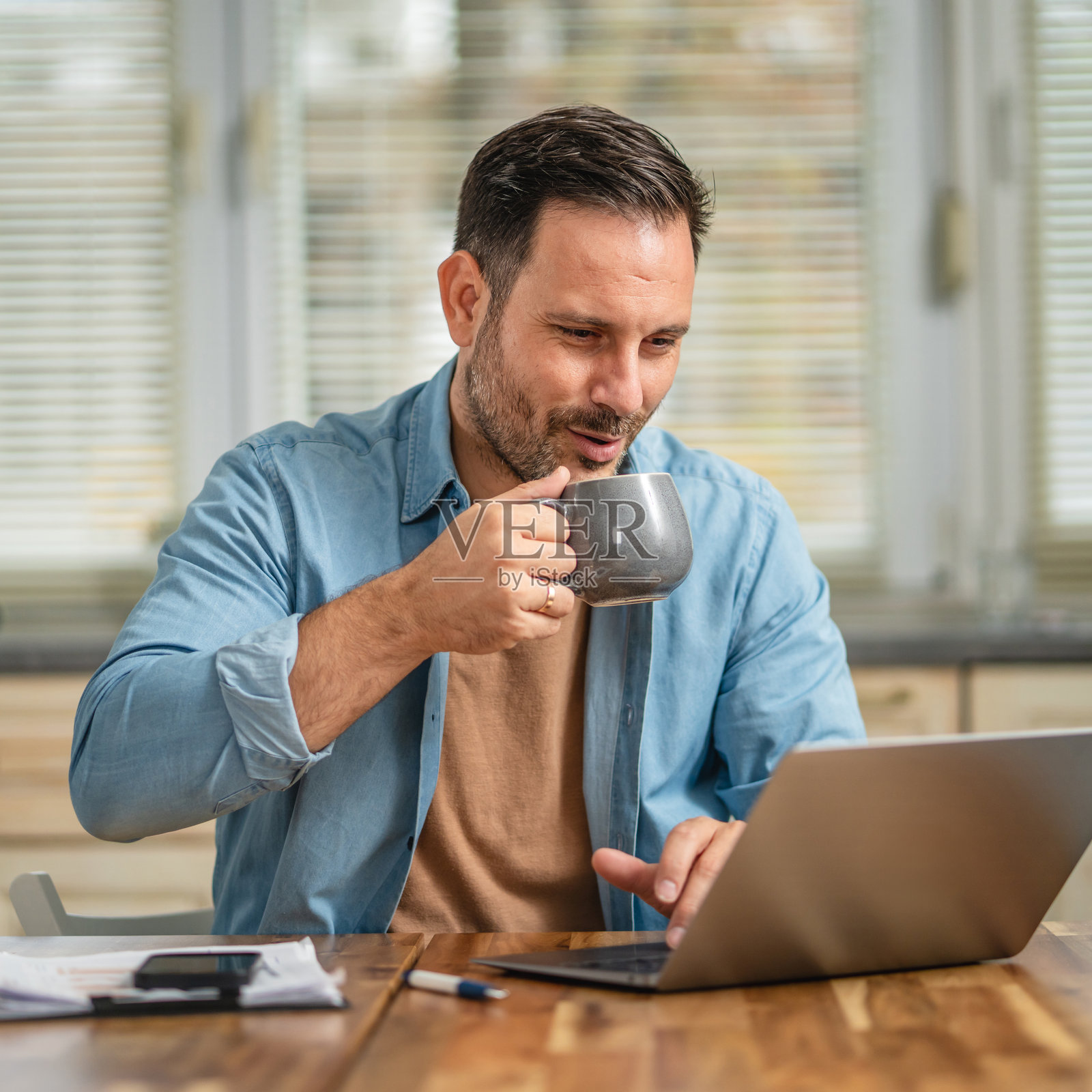 男人在家用笔记本电脑喝咖啡工作照片摄影图片